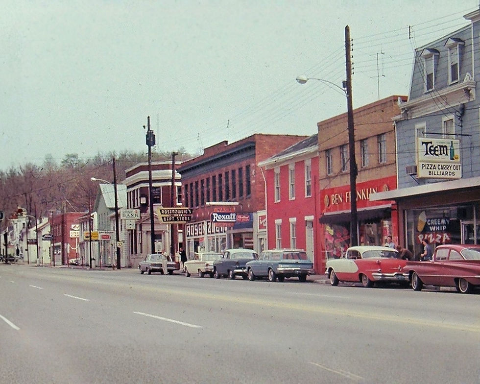 Vintage photo of Main Street in Batavia with brick buildings, old cars, phone poles and wires