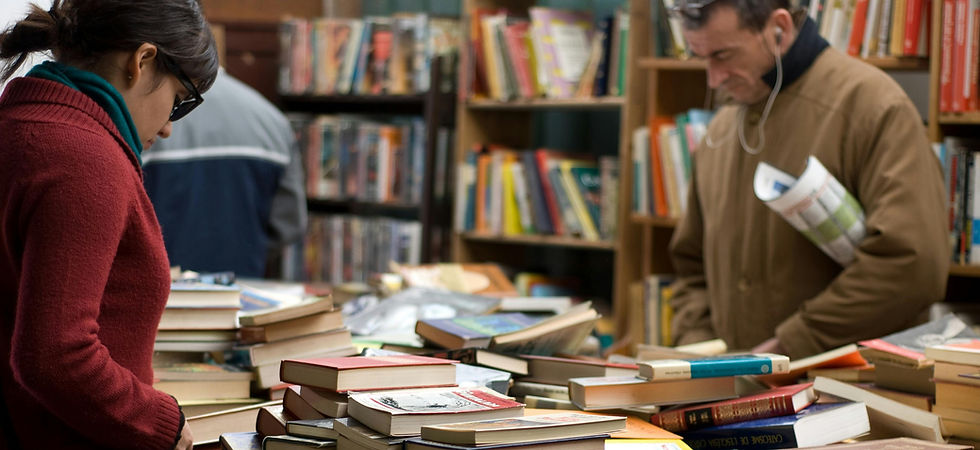 People browsing a table of books at a library used book sale