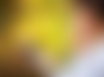 Young woman with earbud checks her phone against a blurred golden autumn background.